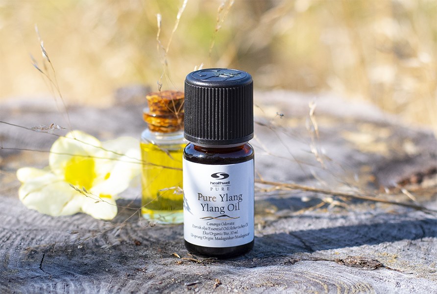 PURE Ylang ylang kukalla ja lasipullolla, jossa on ljy. 